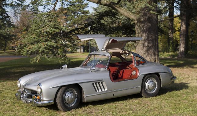 Mercedes 300 SL du Musée de l'automobile Henri Malartre présentée de trois-quarts et portes ouvertes dans le parc du musée.