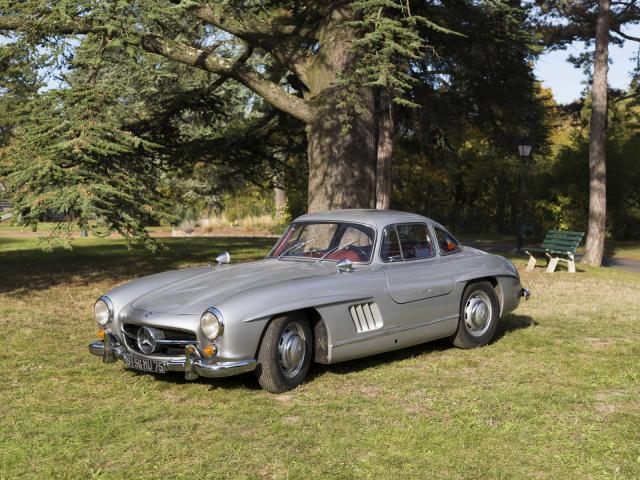 Mercedes 300 SL du Musée de l'automobile Henri Malartre présentée de trois-quarts et portes fermées dans le parc du musée.