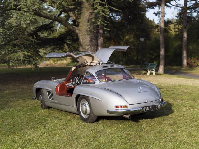 Mercedes 300 SL du Musée de l'automobile Henri Malartre présentée de trois-quarts arrière et portes ouvertes dans le parc du musée.