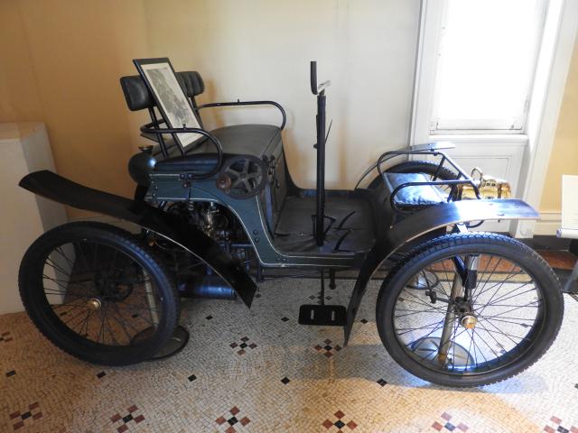 Automobile Decauville 1899 voiturette 3 places vis-à-vis, moteur 2 cylindres à l'arrière, 5CV, vitesse de 36km/h, direction manche à gigot et volant à droite pour les dames
