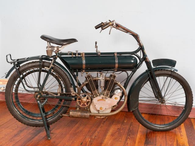 Motocyclette MAGNAT DEBON 4 HP 1914 moteur bicylindre en V 4 temps 500cm3 cylindres borgnes soupapes en tête allumage par magnéto transmission par variateur et courroie suspension avant par fourche télescopique pas de suspension arrière frein arrière double vitesse 90km/h